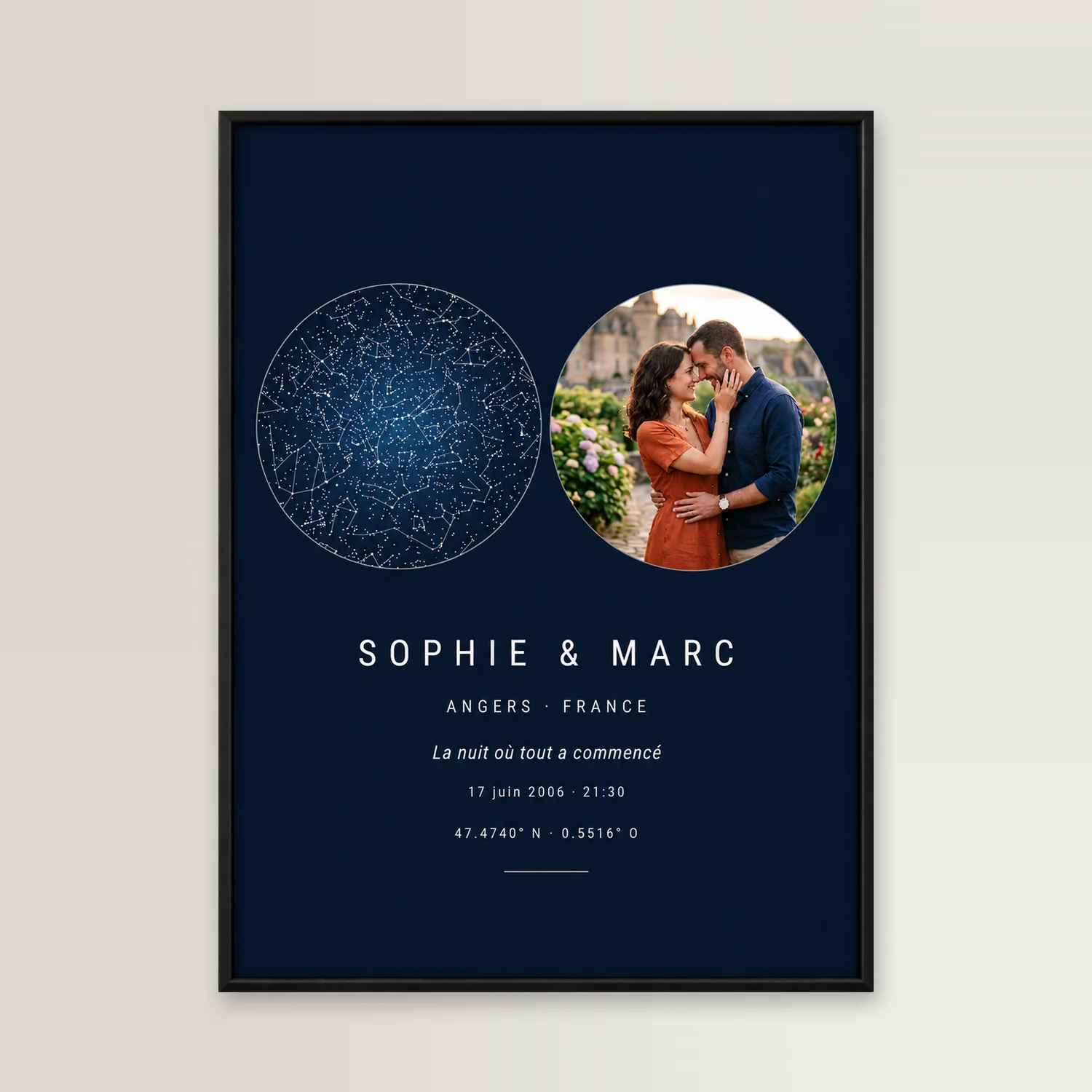 Midnight-blue poster in a thin black frame on a pale wall: a starry sky and, beside it, a round photo of a couple embracing in front of a château, “Sophie & Marc”, Angers, shown in the French version