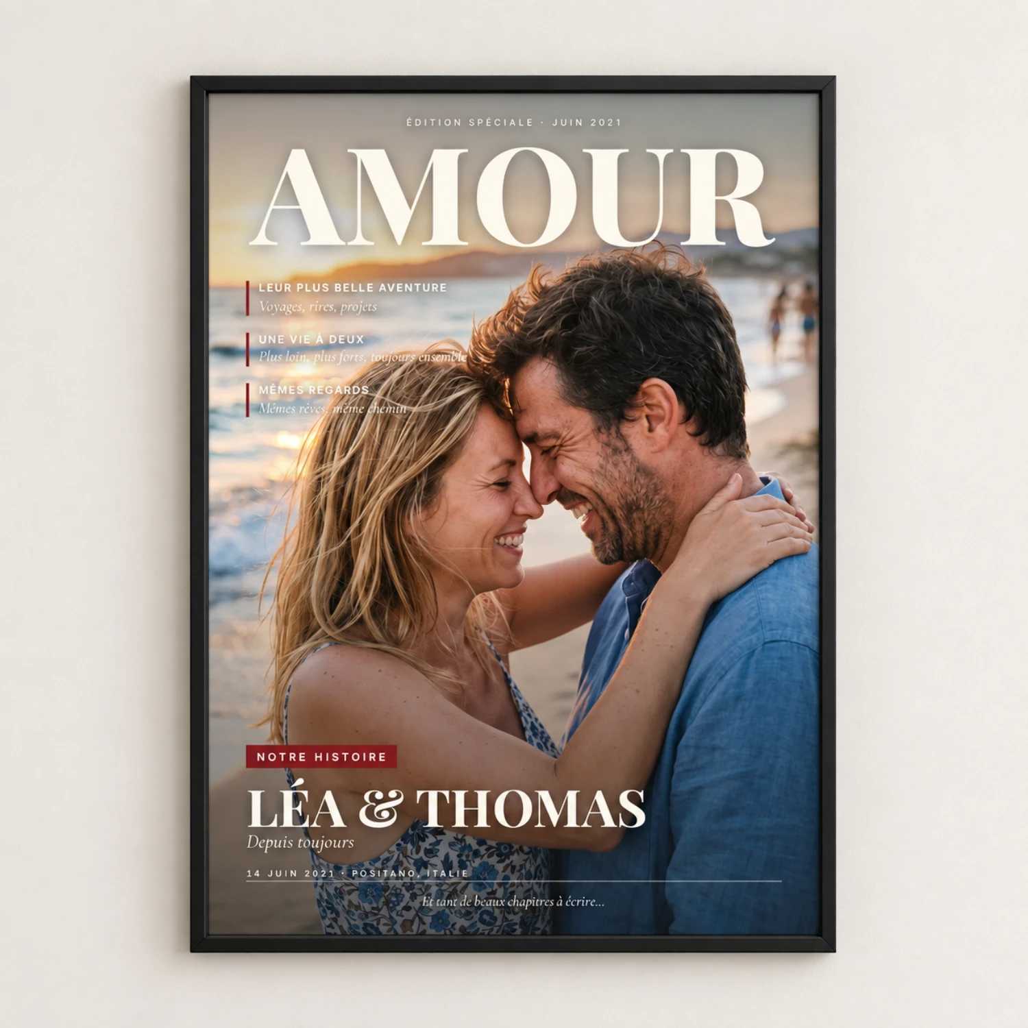 “Amour” magazine cover with the couple on the beach at sunset and “Léa & Thomas”, in a slim black frame on a pale wall, shown in the French version