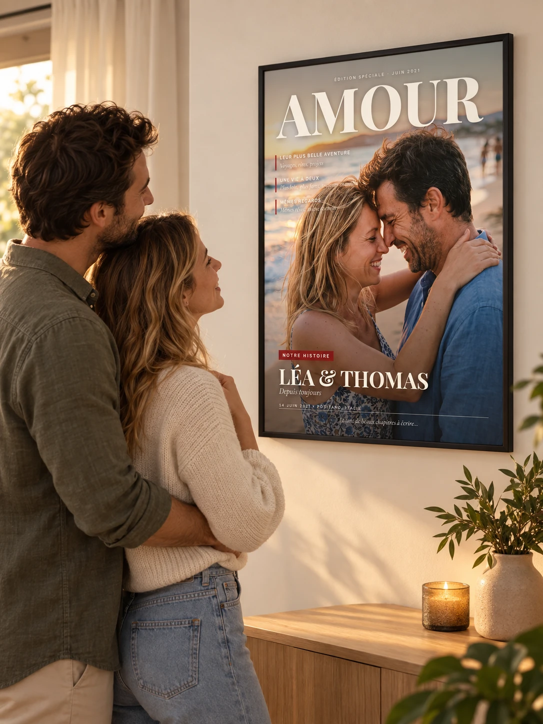 Un couple admire au mur son affiche couverture de magazine personnalisée dans un cadre noir fin, au salon