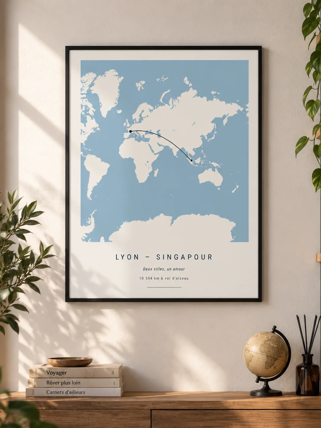 Affiche distance Lyon – Singapour encadrée de noir au mur d’un salon, au-dessus d’un buffet en bois avec un globe