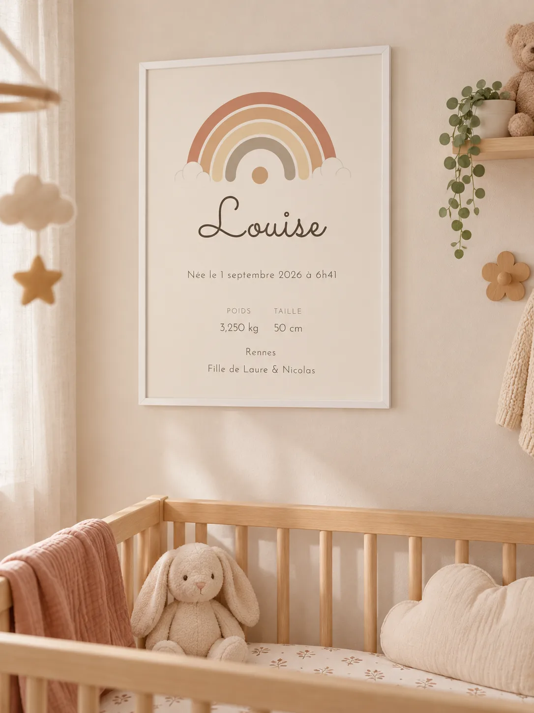 Affiche de naissance arc-en-ciel encadrée de blanc au mur d’une chambre de bébé, au-dessus d’un lit à barreaux