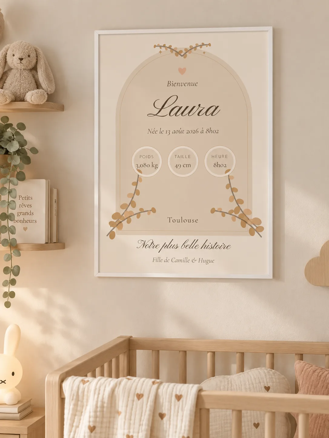 Affiche de naissance arche fleurie encadrée de blanc au mur d’une chambre de bébé, au-dessus d’un lit à barreaux