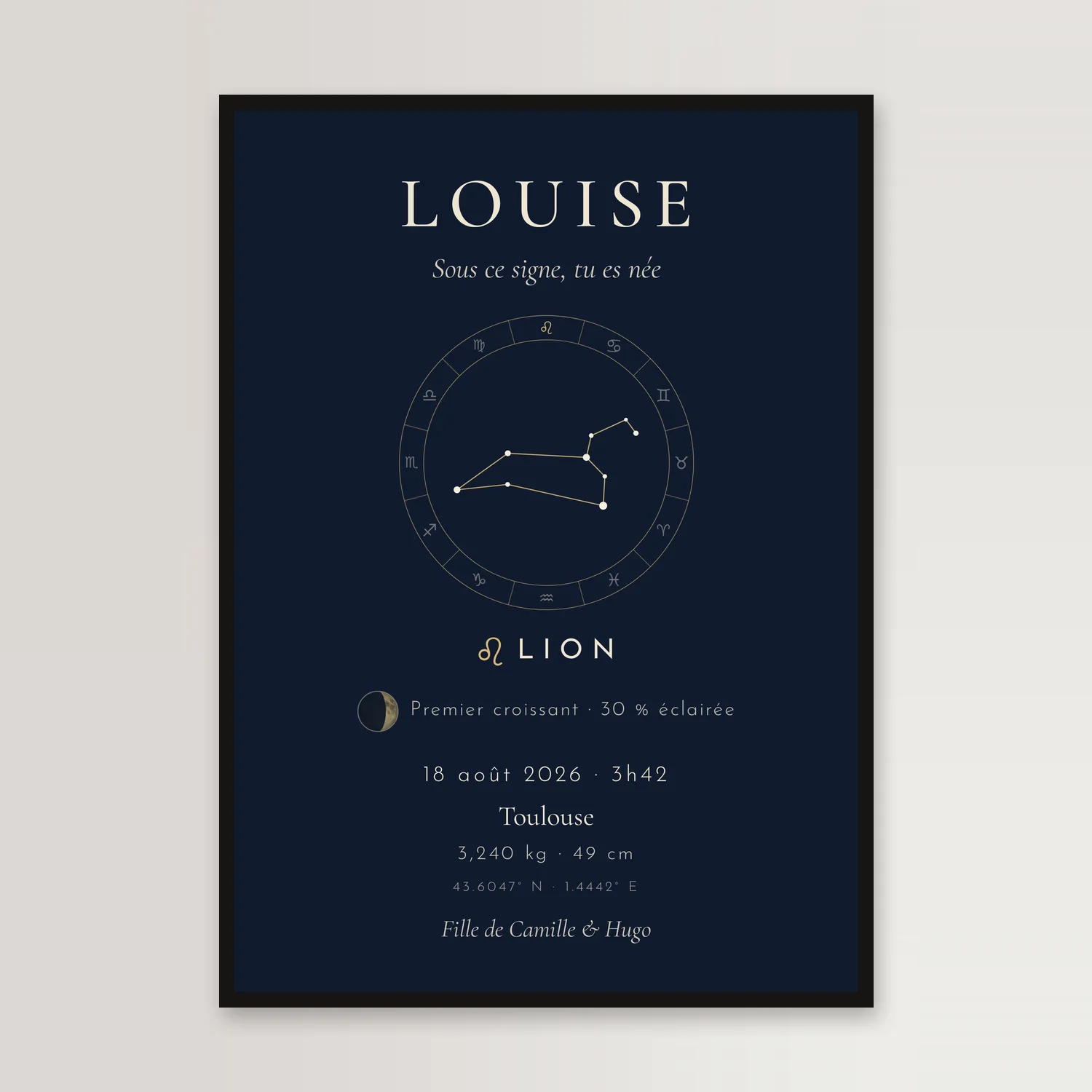 Affiche de naissance bleu nuit dans un cadre noir, sur un mur clair : LOUISE, la constellation du Lion dans la roue des douze signes, la lune du 18 août 2026, Toulouse