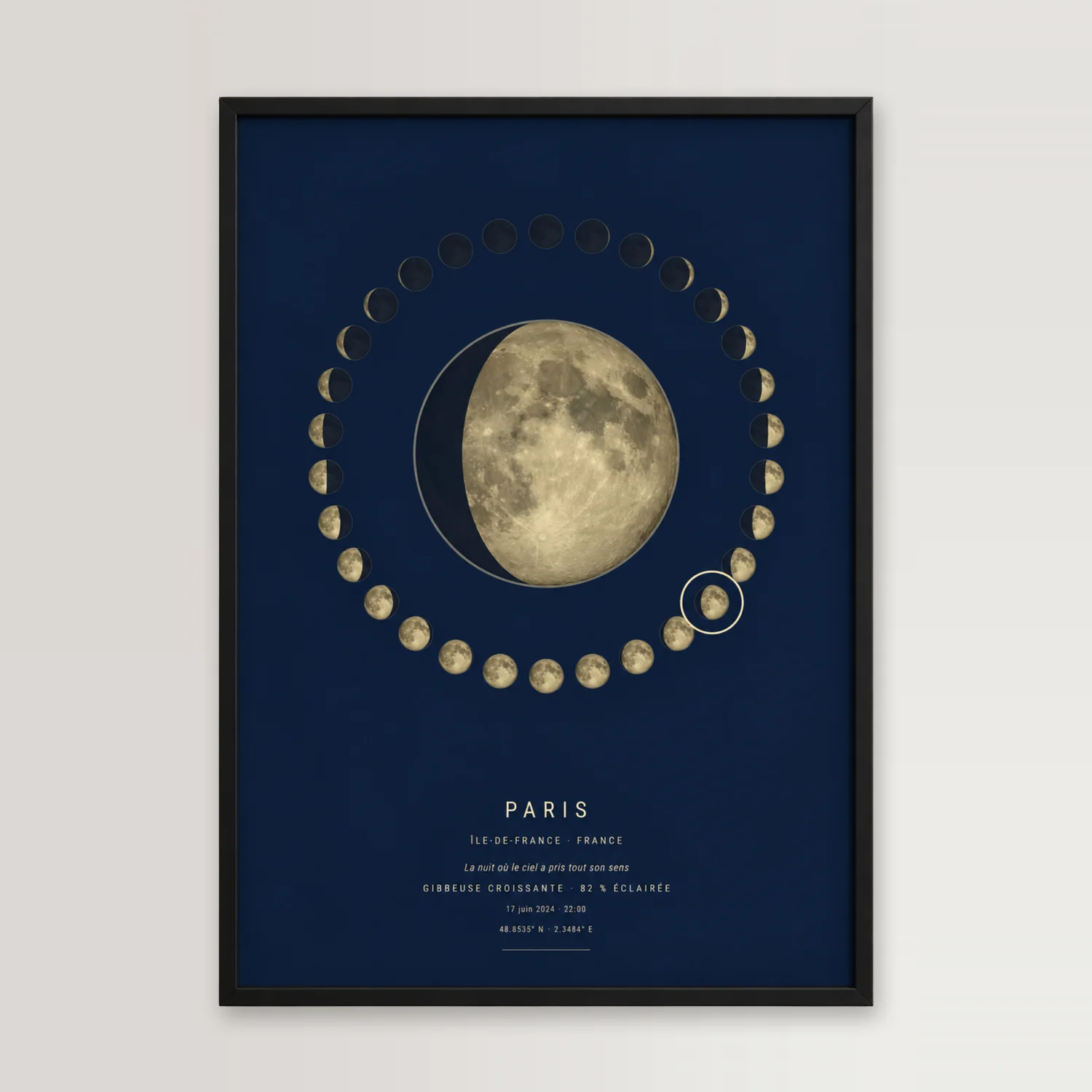 Affiche phase de lune de Paris, dans un cadre noir posé contre un mur clair