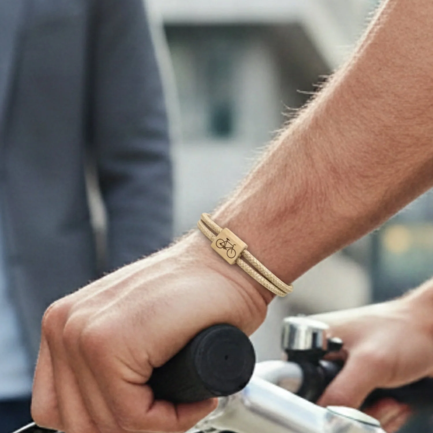 Bracelet worn on a cyclist's wrist, hand on the handlebar