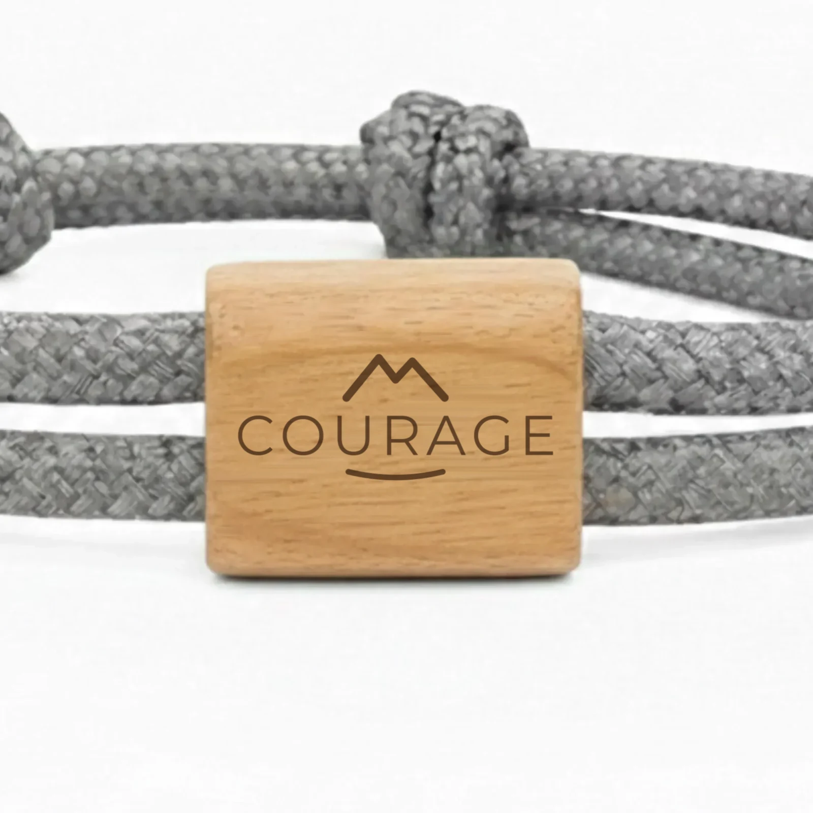 Photographie du bracelet Mot d’intention : gros plan de la pièce en bois de cerisier, gravée d’une étoile et d’un mot en écriture manuscrite.