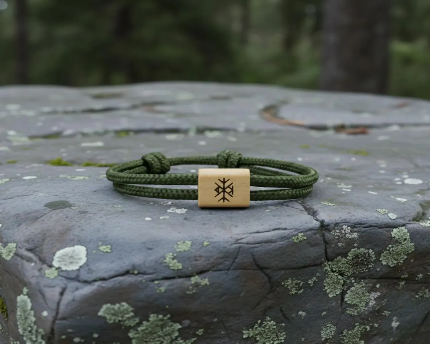 Bracelet vert olive gravé du Vegvísir, sur une pierre couverte de lichen