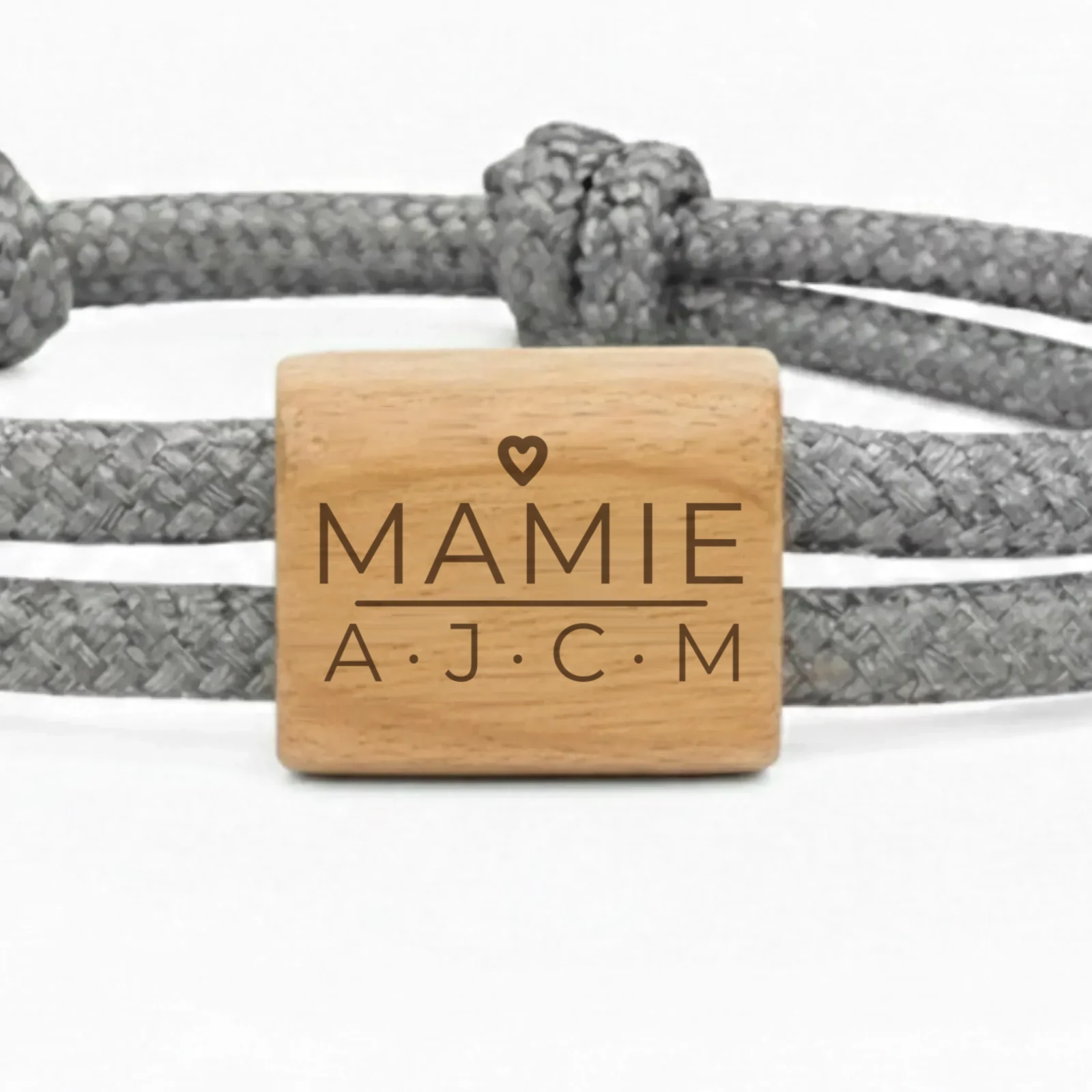 Photographie du bracelet PAPA, MAMAN, PAPI… : gros plan de la pièce en bois de cerisier, gravée du mot PAPA et des initiales des enfants.