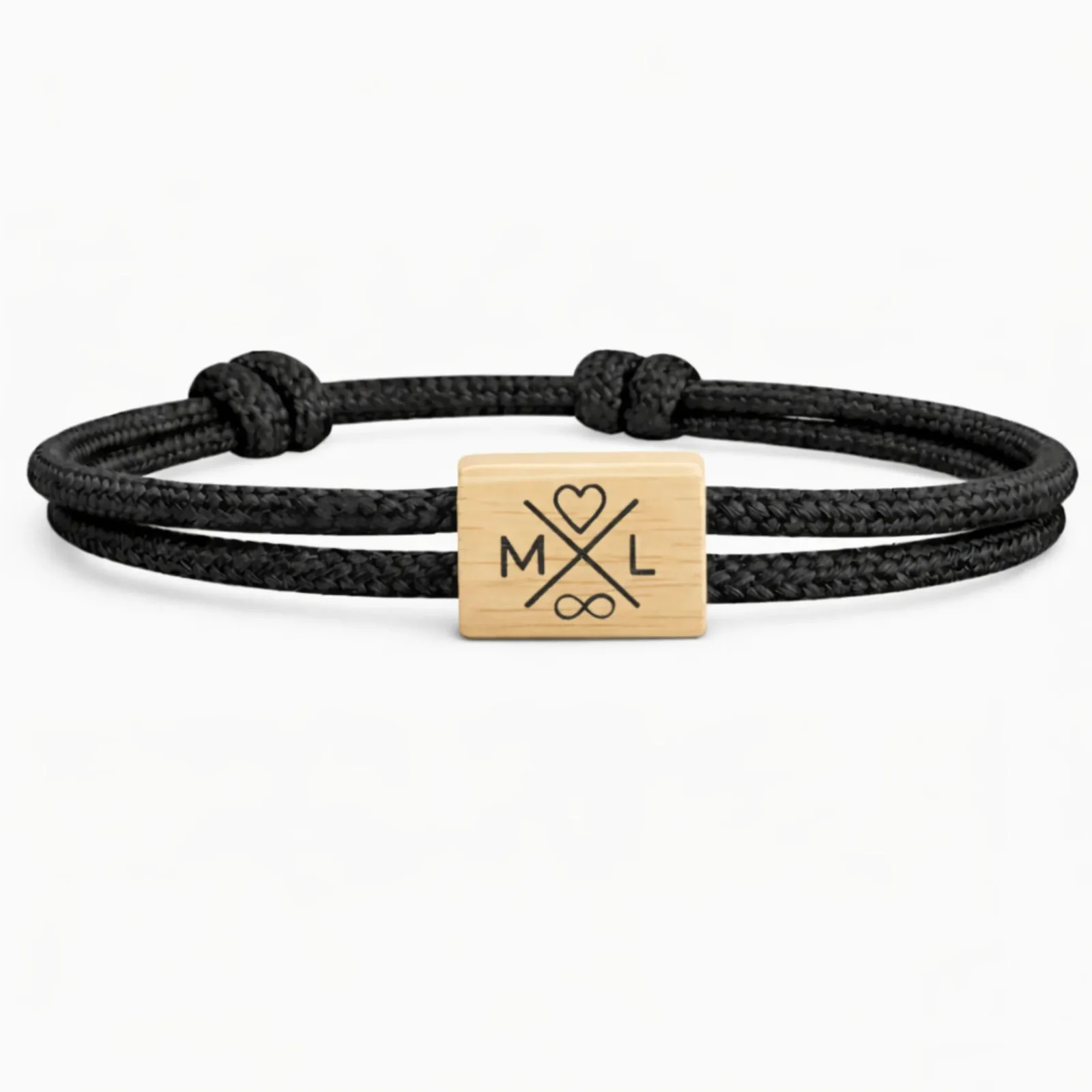 Initiales M et L de part et d'autre d'une croix gravée, cœur au-dessus et infini en dessous, cordon noir